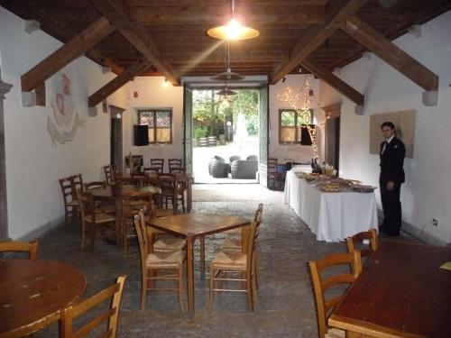 a man standing in a restaurant with tables and chairs at Villa De Rubeis Florit in Tarcento