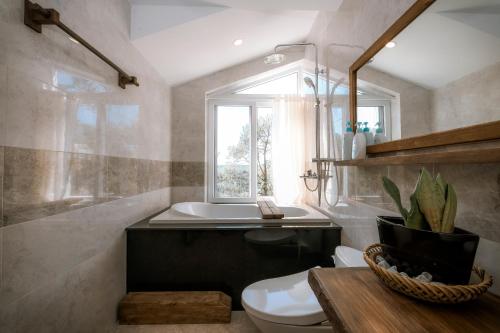a bathroom with a toilet and a sink and a window at Dahlia Dalat in Xuan An