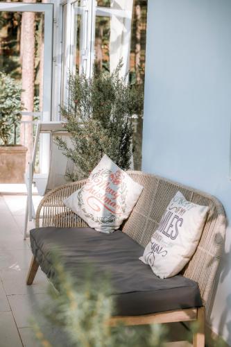 a wicker couch with two pillows on a porch at Dahlia Dalat in Xuan An