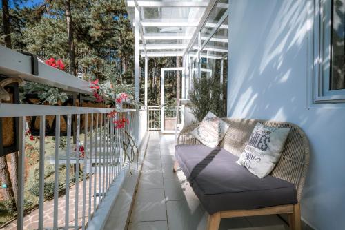 a porch with a couch on a balcony at Dahlia Dalat in Xuan An