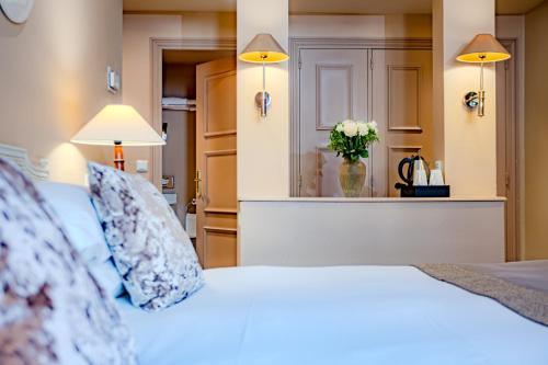 a bedroom with a white bed and a vase of flowers at Le Cavendish in Cannes