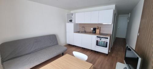un petit salon avec un canapé et une cuisine dans l'établissement Appartement, à Aix-en-Provence
