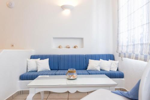 a blue couch in a living room with a table at Yades - All Sea VIew Suites - Adults only in Naousa