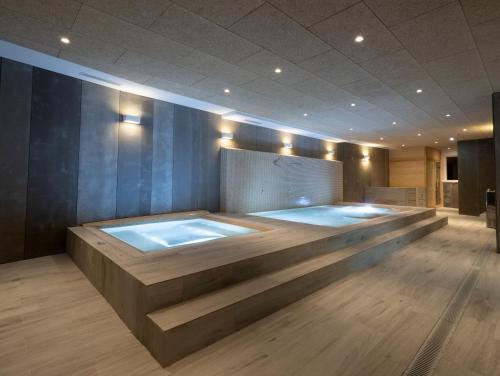 a jacuzzi tub in a room with a wooden floor at Albergue Spa Cruceiro de Pedrouzo in O Pedrouzo