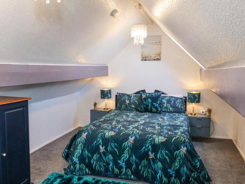 een slaapkamer met een bed met een groen dekbed bij Wayside Farm Cart Cottage in Scarborough