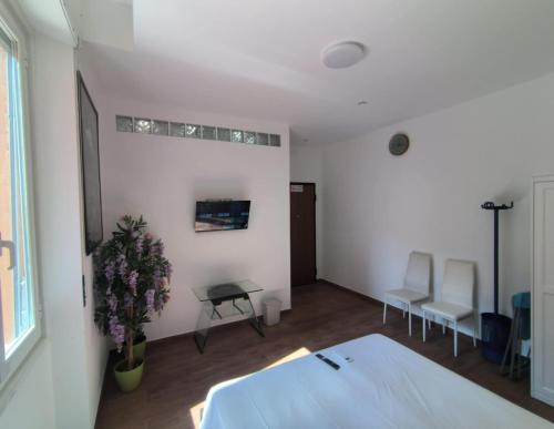 a bedroom with a bed and a table and chairs at Camera Appartamento Terminal Traghetti in Genova