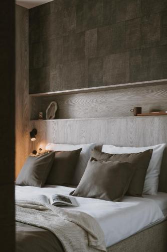 a bedroom with a bed with white sheets and pillows at Apartamenty Marina Rogowo- nowoczesne apartamenty z tarasem- 200m do plaży- między morzem, a jeziorem Resko, parking w cenie! in Rogowo