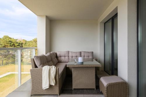 a living room with a couch and a table at Apartamenty Marina Rogowo- nowoczesne apartamenty z tarasem- 200m do plaży- między morzem, a jeziorem Resko, parking w cenie! in Rogowo