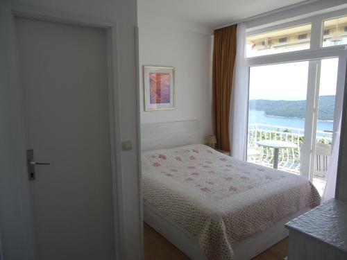 a bedroom with a bed and a large window at Peric Rooms Dubrovnik in Dubrovnik
