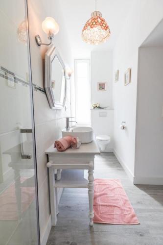 une salle de bain blanche avec un lavabo et un miroir dans l'établissement Les rives de l'escamat, à Sabres