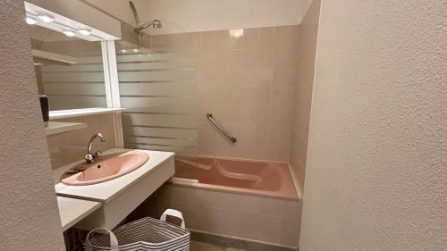 une salle de bain avec un lavabo et une baignoire et un lavabo dans l'établissement Les Pieds dans le Sable – Appartement Unique avec Accès Direct à la Plage du Crotoy, au Crotoy