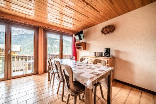 a dining room with a table and chairs and a balcony at La Flèche d'Or in Châtel