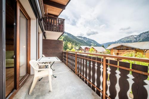 a balcony with a table and chairs and mountains at La Flèche d'Or in Châtel