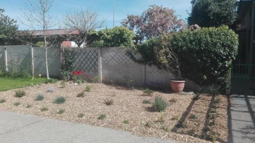 a backyard with a fence and a garden with plants at Het Margrietje in Merkem