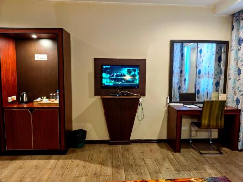 a room with a tv and a desk and a mirror at Great Wall Hotel in Dar es Salaam