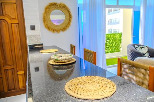 a dining room with a table with two mats on it at Coastal 3BR Vibe, GEM in Nyali in Mombasa