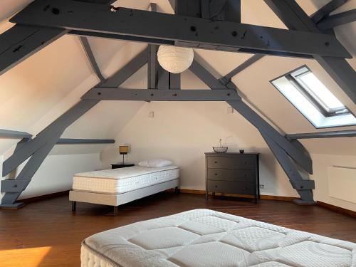 - une chambre mansardée avec un lit et une commode dans l'établissement Appartement 6 personnes, 3 chambres à Mont Saint Eloi, à Mont-Saint-Éloi