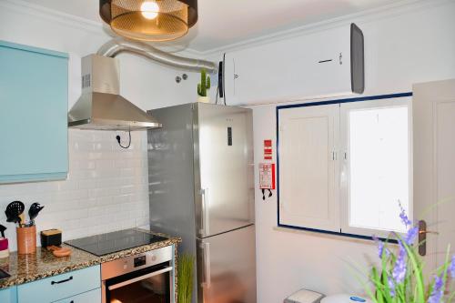 a kitchen with white cabinets and a refrigerator at Lux Downtown Reguengos in Reguengos de Monsaraz