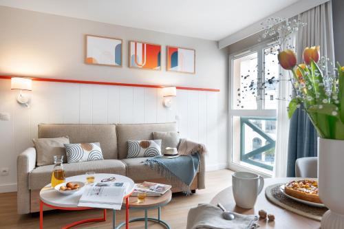a living room with a couch and a table at Résidence Pierre & Vacances Premium Haguna in Biarritz