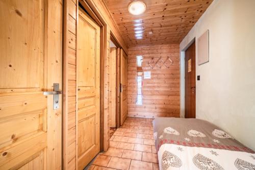 a bedroom with wooden walls and a bed in a room at La Flèche d'Or in Châtel
