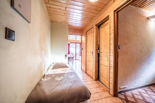 a bedroom with a bed in a room with wooden walls at La Flèche d'Or in Châtel
