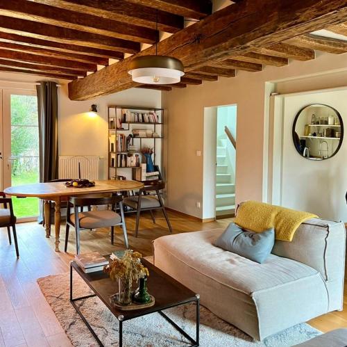 a living room with a couch and a table at Domaine des Pousses, Chambres d'hôtes au coeur d'un village de campagne in Droue-sur-Drouette