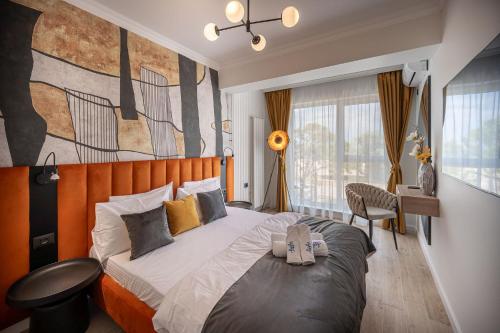 a bedroom with a large bed and a painting on the wall at Sea Breeze Chill Out Infinity Spa & Pool-parking in Mamaia Nord