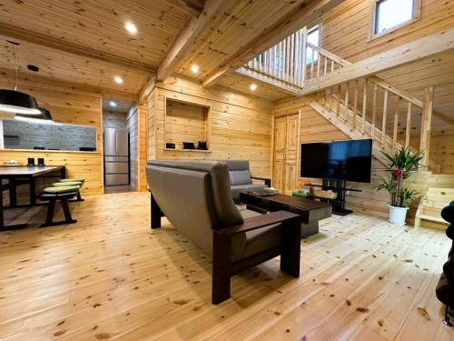 a living room with a couch and a television at P's Wood 伊豆高原 in Ito