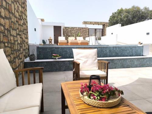 a patio with two chairs and a table with flowers at Valantina's & Mannouel Lardos Luxury Villas in Lardos