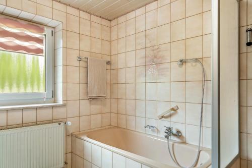 a bathroom with a tub and a window at Relaxinn Bavarian Fewo's in Wegscheid