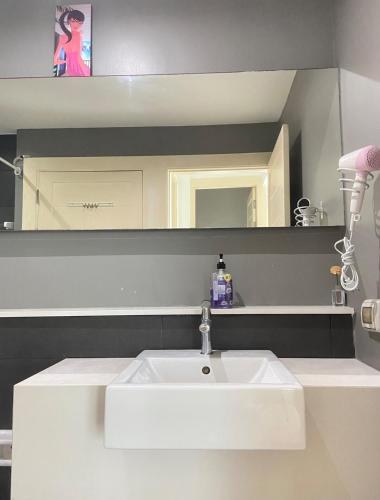 a bathroom with a white sink and a mirror at The Gallery Condominium M in Jomtien Beach