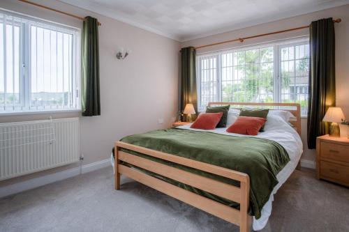a bedroom with a large bed with red pillows at Audreys - 3 Bed Holiday Home - Manorbier in Manorbier