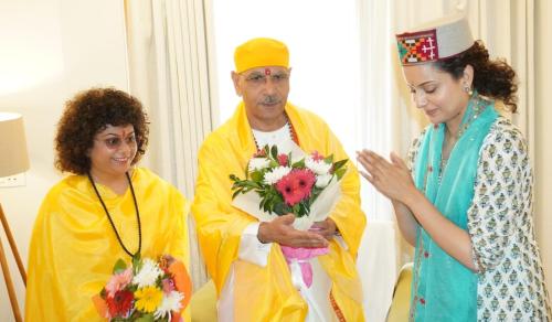 a man and a woman standing next to a woman holding flowers at Anand Vardhan Resorts in Manāli