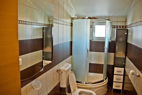 a bathroom with a toilet and a glass shower at Hotel Holy in Međugorje
