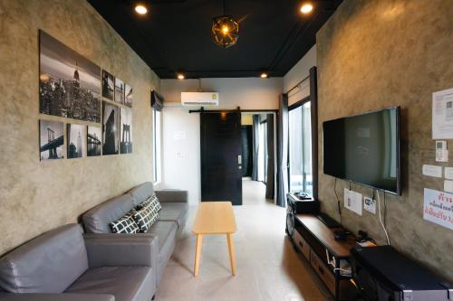 a living room with a couch and a flat screen tv at Modern Life Pool Villa in Hua Hin