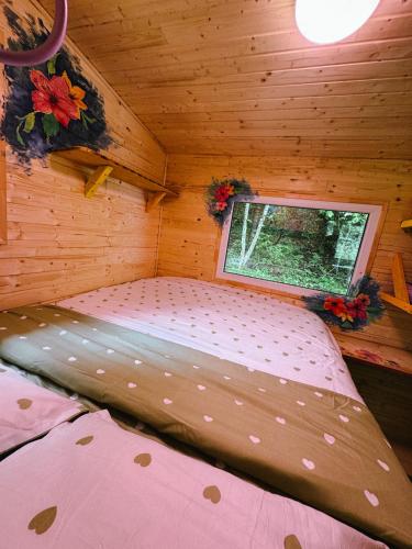 a bed in a room with a window in a cabin at Fain in Lunca Bradului