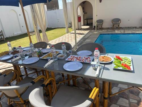 a table with plates of food next to a swimming pool at Golden Land in ‘Ezbet Abu Ḥabashi