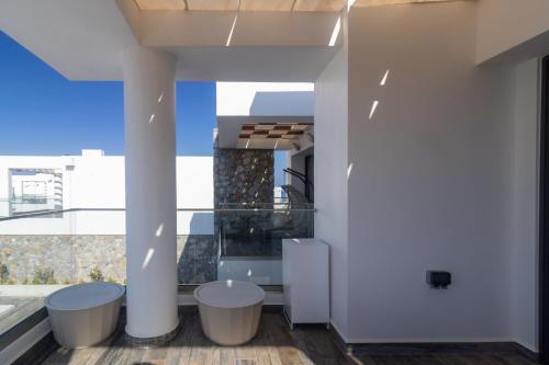 a room with a view of a building with stools at Villa Deja Blu with Private Pool in Kalogrea