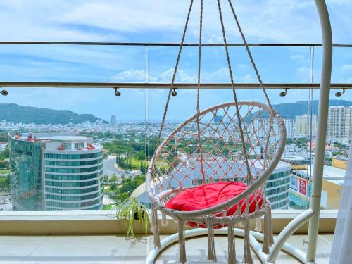 a chair on a balcony with a view of a city at Gạo's Homestay - The Song in Vung Tau
