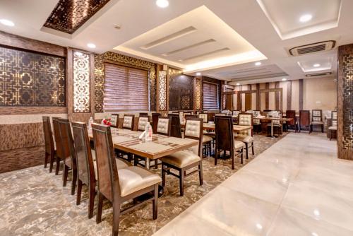 a dining room with wooden tables and chairs at Treebo Riddhi Paradise - 15 mins from Airport in Lucknow
