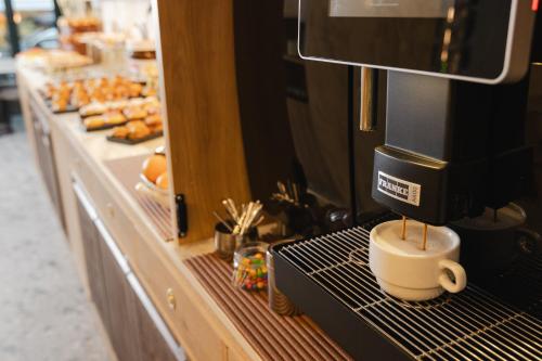 een koffiezetapparaat op een aanrecht met een kopje koffie bij Appartamento SevenAir in Lido di Jesolo