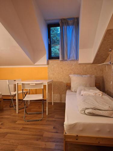 a room with a bed and a table and a window at 2-Rent Group Hostel Rooms AUB162 in Munich
