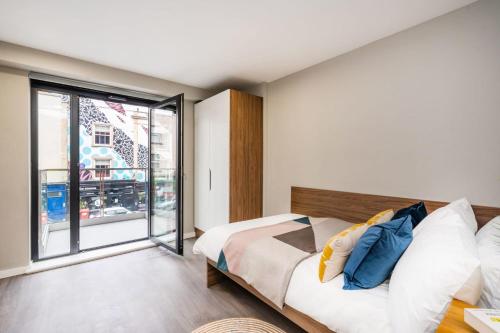 a bedroom with a bed and a large window at Inspiring Spaces at Zinc Works in Bristol