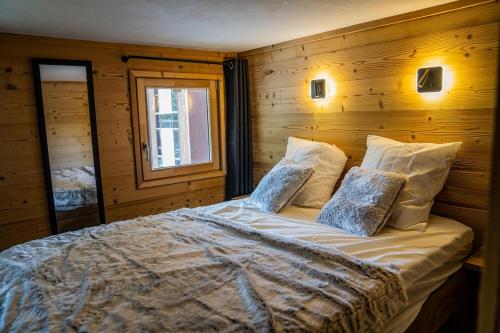 une chambre avec un grand lit avec un mur en bois dans l'établissement Silveralp Cosy Apartment 6 people, à Val Thorens