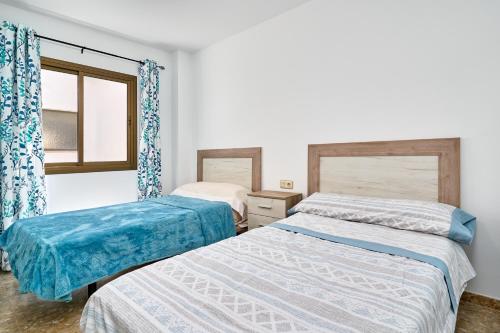 a bedroom with two beds and a window at Cazabonnet in Frigiliana
