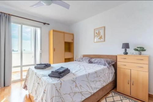 a bedroom with a bed and a dresser and a window at Torreblanca E&S in Torrevieja