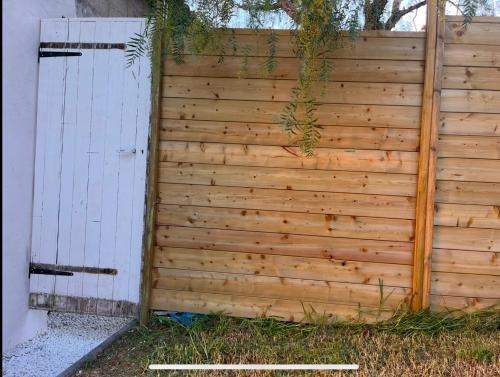 une clôture en bois à côté d'une porte blanche dans l'établissement Atelier, à Saint-Mandrier-sur-Mer