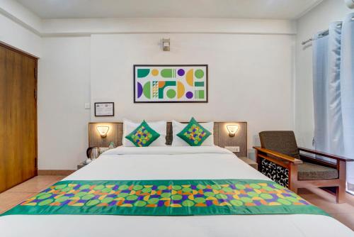 a bedroom with a large bed and two chairs at Treebo Pratham Inn, Manipal in Udupi