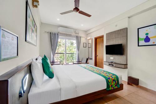 a bedroom with a large white bed and a window at Treebo Pratham Inn, Manipal in Udupi