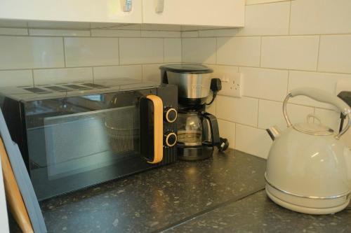 a toaster oven sitting on a kitchen counter at 3 Bedroom House by Brookland Stays Serviced Accommodation Short Lets Leeds in Yeadon